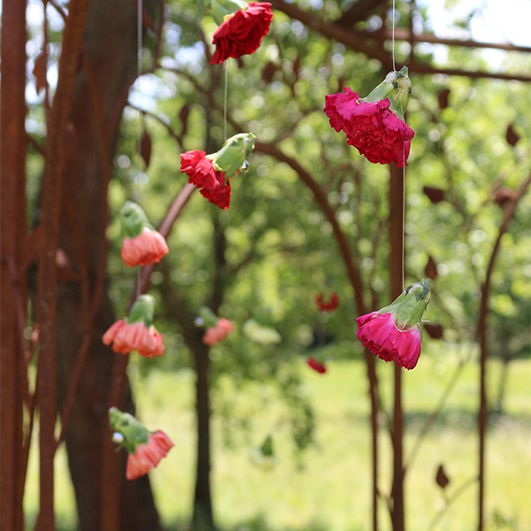 fil de fleurs rose et orange avec oeillets suspendu dans les airs lors d'un mariage