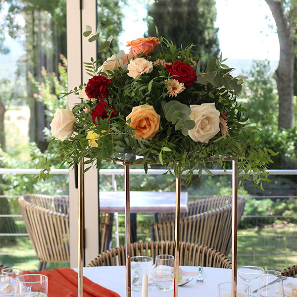 plateforme en or avec composition fleurs terracotta sur table de mariage