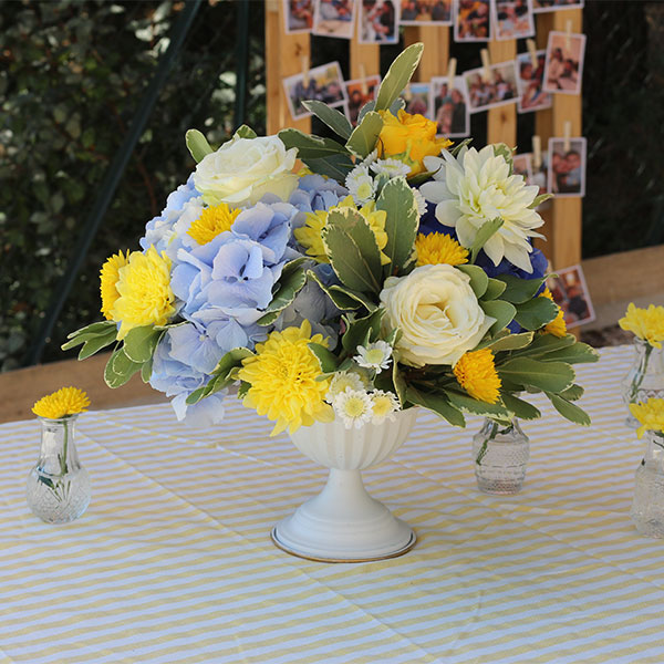 vase baroque fleurs bleu et jaune sur une table de mariage
