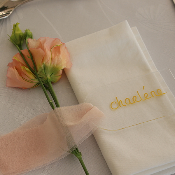 marque place avec une fleur couleur pêche pour une table de mariage